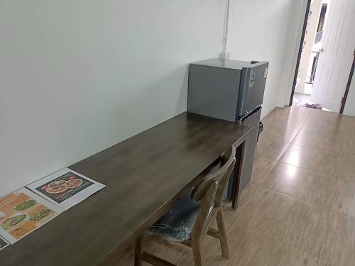 una mesa de madera con TV encima. en Comfy Hotels Suvarnabhumi Airport, en Samut Prakan