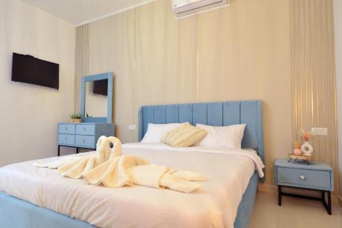 a bedroom with a bed with a towel animal on it at פינוק של סוויטה in Manot