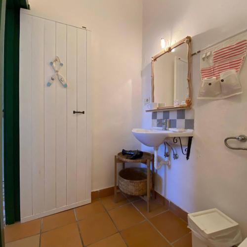 un bagno con lavandino, WC e specchio di bolinajazz a Lampedusa
