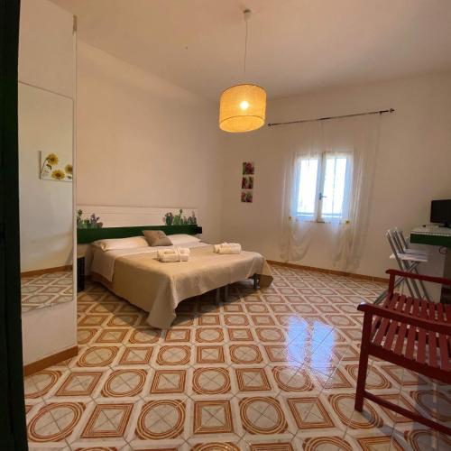 una camera da letto con due letti e una lampada a sospensione di bolinajazz a Lampedusa