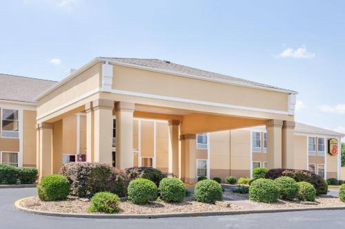 a hotel building with bushes in front of it at Super 8 by Wyndham Evansville North in Warrenton