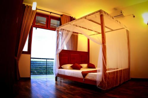 a bedroom with a canopy bed in a room at Cirute' Talwatte, Kandy in Kandy