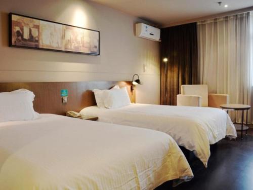 a hotel room with two beds and a table at Jinjiang Inn Select Nanjing South Railway Station North Square in Nanjing