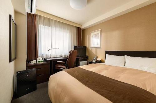 a hotel room with a bed and a desk at Hotel Sealuck Pal Kofu in Showa