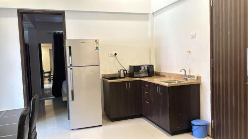 a kitchen with a refrigerator and a sink at Vista Vagator Junction by Dia Hotels and Homes in Anjuna