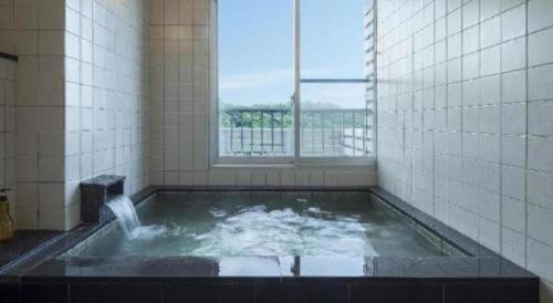 een jacuzzi in een badkamer met een raam bij MISAKI TERRACE in Ako