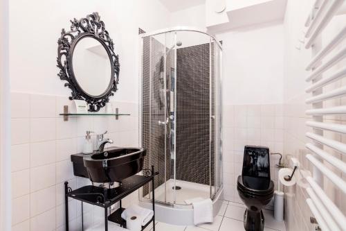 a bathroom with a toilet, sink and mirror at ARTHOTEL STALOWA 52 in Warsaw