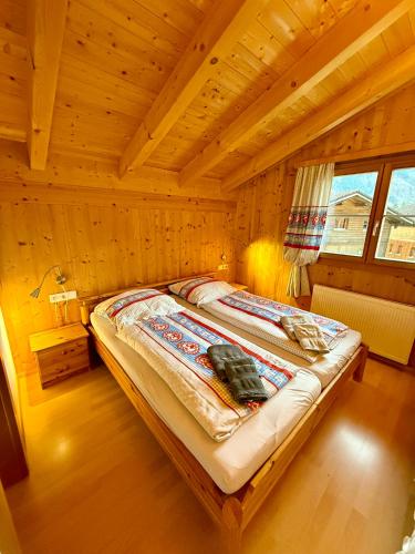 a bedroom with a bed in a wooden room at Chalet Auszeit Montafon in Bartholomäberg