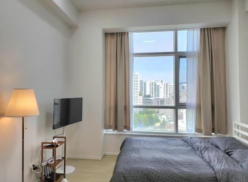 une chambre avec un lit et une grande fenêtre dans l'établissement Seoul Station Urban View Room, à Séoul