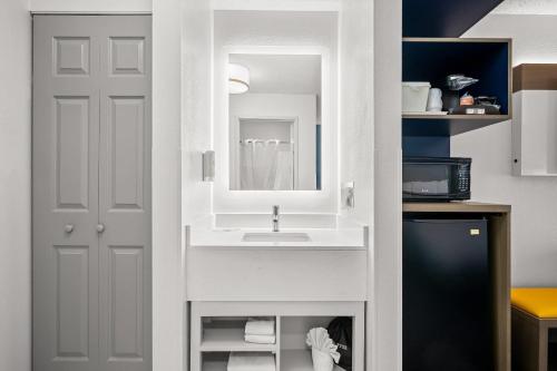 un baño con lavabo y espejo en Comfort Inn Indianapolis East, en Indianápolis