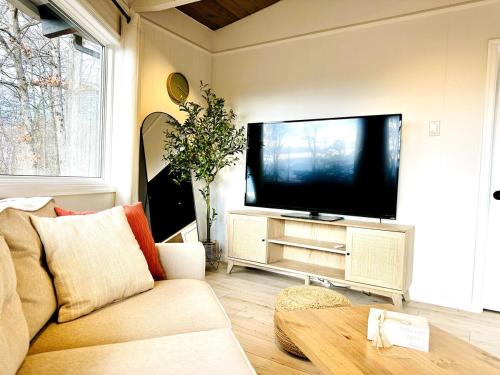 Una sala de estar con un sofá y un televisor de pantalla plana. en Round House with Mountain View and Hot Tub, en Luray