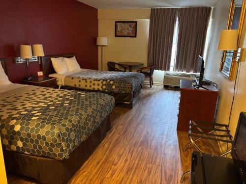 a hotel room with two beds and a television at Econo Lodge Yazoo City in Yazoo City