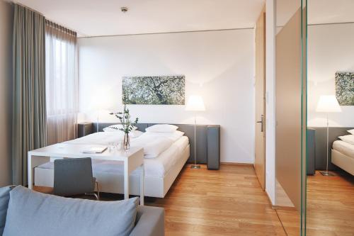a living room with a white couch and a table at Hotel am See in Hard