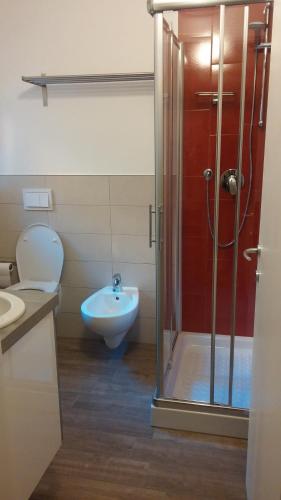 y baño con ducha, aseo y lavamanos. en Le Stanze Apartament, en Bolonia