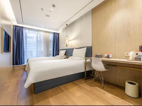 Ένα ή περισσότερα κρεβάτια σε δωμάτιο στο Hanting Hotel Shanghai South Shaanxi Road Subway Station