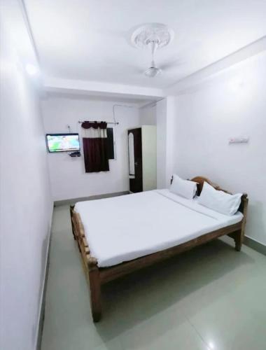 a white bedroom with a bed in a room at Hotel Luxury Heaven in Deoghar