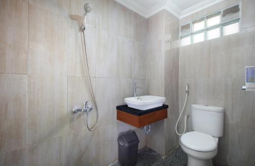 ein Badezimmer mit Toilette, Waschbecken und Dusche in der Unterkunft Family & Superior Hotel Malioboro-Yogyakarta in Sentool