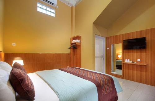 ein Schlafzimmer mit einem großen Bett und einem Fernseher in der Unterkunft Family & Superior Hotel Malioboro-Yogyakarta in Sentool