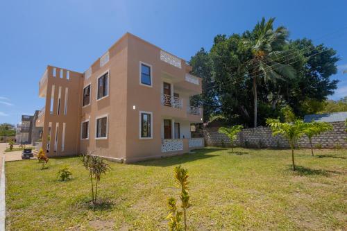 a large house with a yard in front of it at Jamii Villas Diani in Kwale