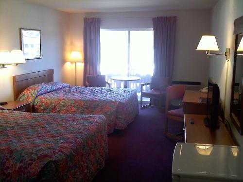 een hotelkamer met 2 bedden en een tafel bij Carriage House Motor Inn in Lake Placid