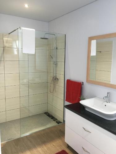 a bathroom with a sink and a glass shower at Villa Pinheira III heated pool in Calheta