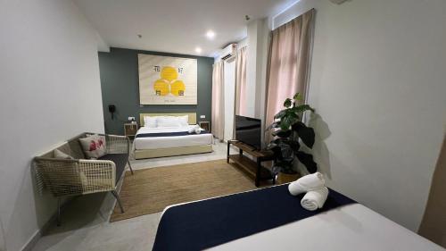 a bedroom with a bed and a living room at Cojoy Hotel @ Chinatown in Kuala Lumpur