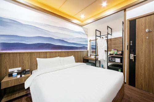 a bedroom with a bed and a painting on the wall at A25 Hotel - 21 Nghia Tan in Hanoi
