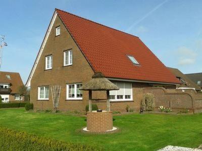 ein großes Backsteinhaus mit einem roten Dach in der Unterkunft Haus Hanni Ferienwohnung Hanni in Hage Ostfriesland direkt am Kiessee und Kurpark - Nordseenah in Berumbur