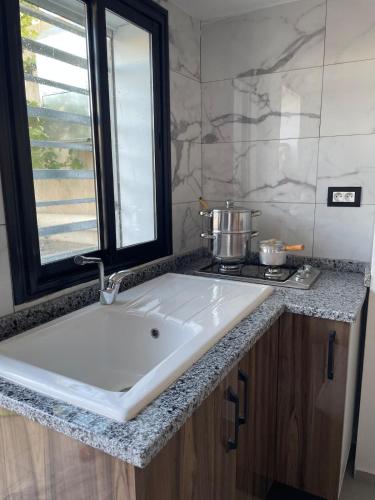 a white sink in a bathroom with a window at Studio Chic in Mahdia