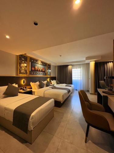 ein Hotelzimmer mit zwei Betten und einem Fernseher in der Unterkunft Aroma Hotel in Aqaba