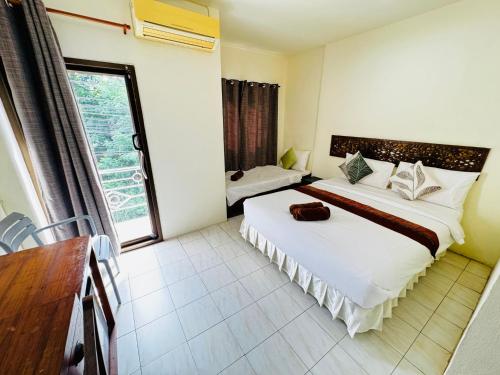 a hotel room with two beds and a window at Penzy Guest House in Chaweng