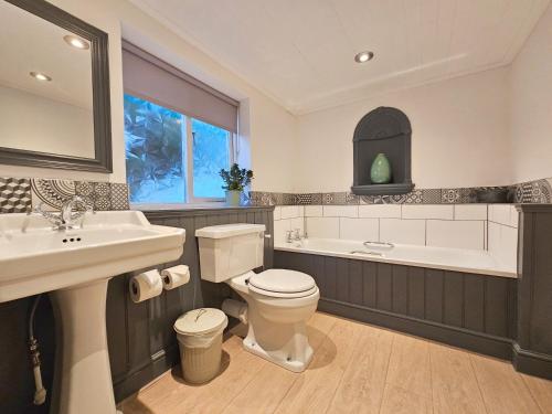 a bathroom with a toilet and a sink and a tub at The Derwentwater Hotel in Keswick