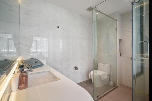 ナイトンビーチにあるModern 1506 Condo in Wyndham Gardens on the beachのシャワーとトイレ付きの白いバスルーム