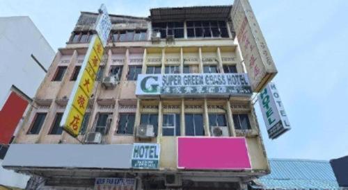 a building with signs on the side of it at SPOT ON 90625 Super Green Grass Hotel in Yong Peng