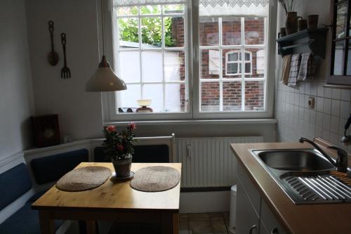 a kitchen with a table and a sink and a window at Ferienwohnung Am Mittelburgwall in Friedrichstadt