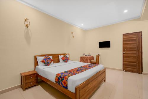 a bedroom with a bed and a television in it at FabHotel Marine - Vishnu Temple Bada Lalpur in Varanasi