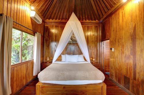 a bedroom with a bed with a mosquito net at Bali Rahayu Homestay in Munduk