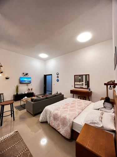 a large bedroom with a bed and a couch at Cozy studio AlJimi in Al Ain