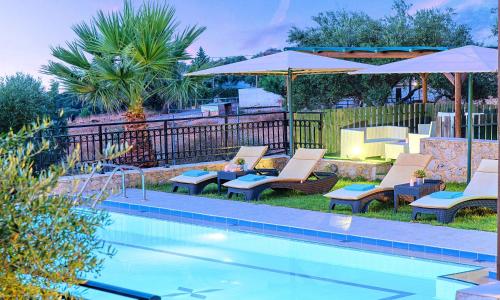 een zwembad met ligstoelen en parasols naast een zwembad bij Ferienhaus Für 12 Personen In Chania, Kreta West Kreta in Georgioupolis