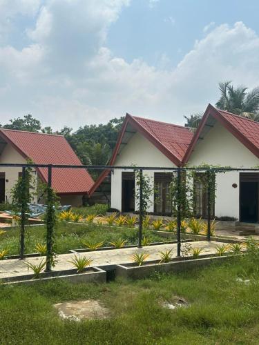 ein Haus mit roten Dächern und einem Garten in der Unterkunft OrientalResort Kekirawa in Kekirawa