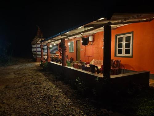 a house with a table and chairs outside at night at Dark Sky Homestay in Mudigere