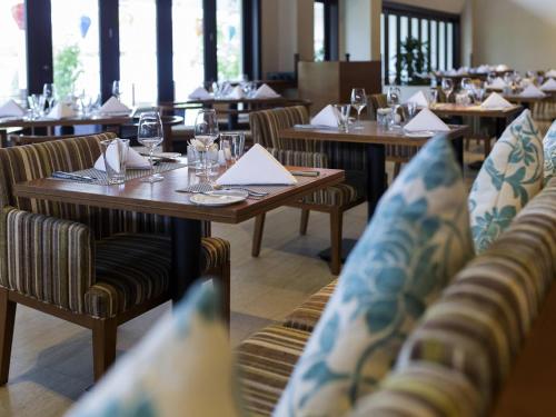 een restaurant met tafels en stoelen met glazen en servetten bij Pullman Danang Beach Resort in Da Nang