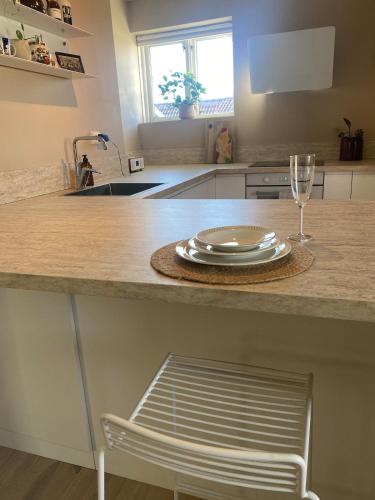 a kitchen counter with a plate and a wine glass at Central Apartment Stavanger 2 Bedroom Sleeps 4 in Stavanger