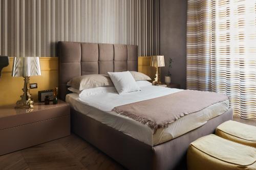 a bedroom with a large bed and a large window at Le Quattro Dame Luxury Suites in Rome