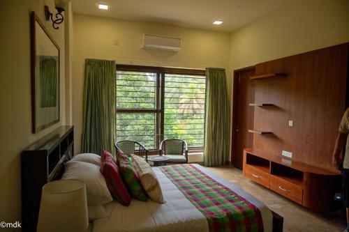Ένα ή περισσότερα κρεβάτια σε δωμάτιο στο Pollachi Riverhouse, A CGH Earth Saha experience