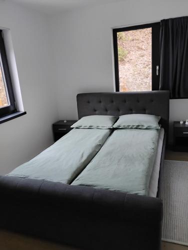 un grand lit dans une chambre avec une fenêtre dans l'établissement Cabana de la râu! Ciubăr aero hidro masaj, à Măguri-Răcătău