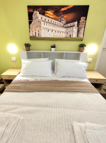 a bedroom with a large bed with a painting on the wall at Villa Mehari in Pisa