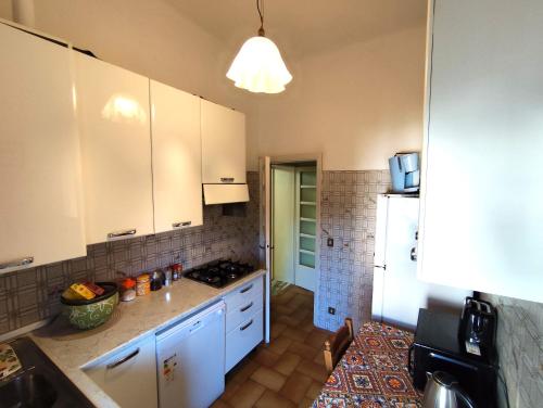 une cuisine avec des armoires blanches et un réfrigérateur blanc dans l'établissement Villa Mehari, à Pise