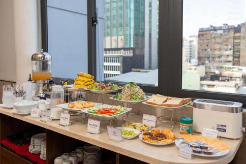 a buffet with many plates of food on a table at A25 Hotel - 35 Mạc Thị Bưởi in Ho Chi Minh City