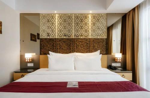 a bedroom with a large bed with a large headboard at Hotel Radhe in New Delhi